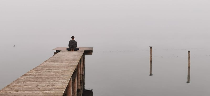 Person meditating at sunrise